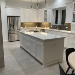 Modern kitchen design featuring white cabinetry, stainless steel appliances, and a spacious island, showcasing The Perfect Cabinet Company's custom cabinetry and remodeling expertise.