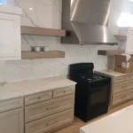 Modern kitchen featuring custom cabinetry, black stove, and marble countertops, highlighting The Perfect Cabinet's remodeling services.
