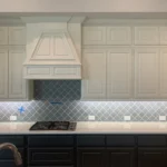Modern kitchen design featuring custom cabinetry, a stylish range hood, and elegant backsplash tiles, highlighting The Perfect Cabinet Company's remodeling expertise.