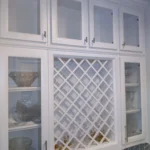 Custom white cabinetry with glass doors and lattice design, showcasing kitchen storage options, featured in The Perfect Cabinet's gallery for remodeling services.