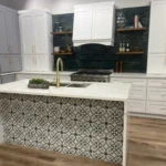 Modern kitchen design featuring a stylish island with intricate tile pattern, white cabinetry, and dark backsplash, showcasing custom cabinetry and remodeling services by The Perfect Cabinet Company.