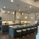 Modern kitchen design featuring custom cabinetry, a large island with seating, pendant lighting, and integrated appliances, showcasing The Perfect Cabinet's remodeling services.