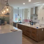 Modern kitchen featuring custom cabinetry, white countertops, and pendant lighting, showcasing a blend of functionality and style for remodeling inspiration.