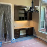 Modern home office space featuring custom cabinetry, workspace with lighting, and large window, part of The Perfect Cabinet Company's remodeling services.