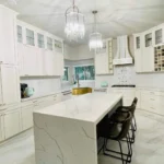 Modern kitchen with white cabinetry, marble island, and stylish pendant lighting, showcasing custom cabinetry and design expertise by The Perfect Cabinet Company.