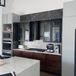 Modern kitchen design featuring sleek cabinetry, marble countertops, built-in appliances, and a minimalist aesthetic, showcasing The Perfect Cabinet Company's remodeling expertise.