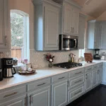 Modern kitchen with light gray cabinetry, stainless steel appliances, and a bright, inviting atmosphere, showcasing The Perfect Cabinet Company's custom cabinetry and remodeling services.