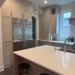 Modern kitchen interior featuring custom cabinetry, quartz countertop island, and stainless steel appliances, showcasing The Perfect Cabinet Company's remodeling expertise.