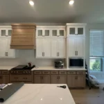 Modern kitchen design featuring custom cabinetry, white cabinets with wood accents, and a spacious island, showcasing The Perfect Cabinet Company's remodeling services.