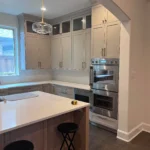 Modern kitchen featuring custom cabinetry, stainless steel appliances, and a spacious island with a light fixture above, showcasing The Perfect Cabinet Company's remodeling expertise.
