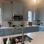 Modern kitchen featuring blue cabinetry, stainless steel appliances, and a large island with a sink, showcasing custom cabinetry and remodeling services by The Perfect Cabinet Company.
