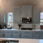 Modern kitchen with light blue cabinetry, stainless steel appliances, and a white countertop, showcasing a stylish and functional design for remodeling projects.
