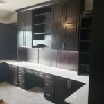 Modern black cabinetry with sleek design and white countertop in an office setting, showcasing custom cabinetry solutions by The Perfect Cabinet.