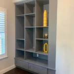 Modern gray cabinetry with open shelving and decorative accents, showcased in an office setting, highlighting The Perfect Cabinet's design and craftsmanship.