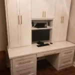 White cabinetry desk setup with storage and monitor, showcasing The Perfect Cabinet's office design and remodeling capabilities.