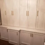Modern white cabinetry with gold handles in an office setting, showcasing storage solutions and design elegance for The Perfect Cabinet gallery.