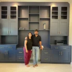 Couple standing in front of custom blue cabinetry showcasing The Perfect Cabinet's design and craftsmanship in an office setting.