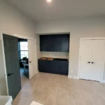 Modern office interior featuring sleek dark cabinetry and light tile flooring, showcasing The Perfect Cabinet's craftsmanship and design for remodeling inspiration.