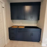 Modern dark blue cabinetry with upper and lower storage units, featuring open spaces for sink installation, showcasing The Perfect Cabinet's design and craftsmanship.