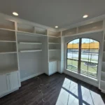 Bright office space featuring white cabinetry and built-in shelving, showcasing craftsmanship from The Perfect Cabinet, ideal for remodeling inspiration.