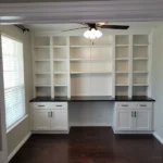 Modern office cabinetry with white shelves and dark countertops, showcasing a clean design ideal for remodeling and organization.