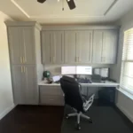 Office space featuring modern cabinetry, a desk with dual monitors, and ergonomic chair, showcasing The Perfect Cabinet's design capabilities.