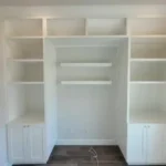 Modern white cabinetry with open shelves and closed storage, showcasing custom design for office spaces by The Perfect Cabinet.