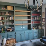 Modern office cabinetry featuring a blue finish, open shelving, and decorative accessories, showcasing The Perfect Cabinet's craftsmanship in office design.