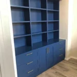 Blue cabinetry unit with open shelves and drawers, showcasing modern design suitable for office spaces.