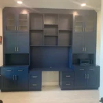 Custom blue cabinetry with multiple storage compartments and a sleek design, featured in an office setting, showcasing The Perfect Cabinet's craftsmanship and remodeling services.