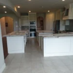 Custom kitchen island design featuring white cabinetry, granite countertops, and a spacious layout in a modern kitchen setting.