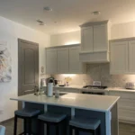 Custom kitchen island with seating, modern cabinetry, and stylish decor in a well-lit kitchen setting.