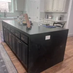 Custom kitchen island with dark cabinetry and a sleek countertop, showcasing storage options and design elements relevant to The Perfect Cabinet's offerings.