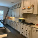 Custom kitchen cabinetry with light-colored cabinets, granite countertops, and modern appliances in a spacious kitchen setting, showcasing The Perfect Cabinet's design style.