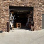 Entrance of The Perfect Cabinet Shop showing wooden cabinetry materials and tools, emphasizing custom cabinetry craftsmanship.