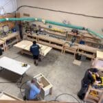 Workshop environment with craftsmen working on custom cabinetry projects, showcasing tools and materials used in cabinetry at The Perfect Cabinet Shop.