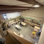 Workshop interior showcasing woodworking area with tools and materials, emphasizing custom cabinetry craftsmanship at The Perfect Cabinet Shop.