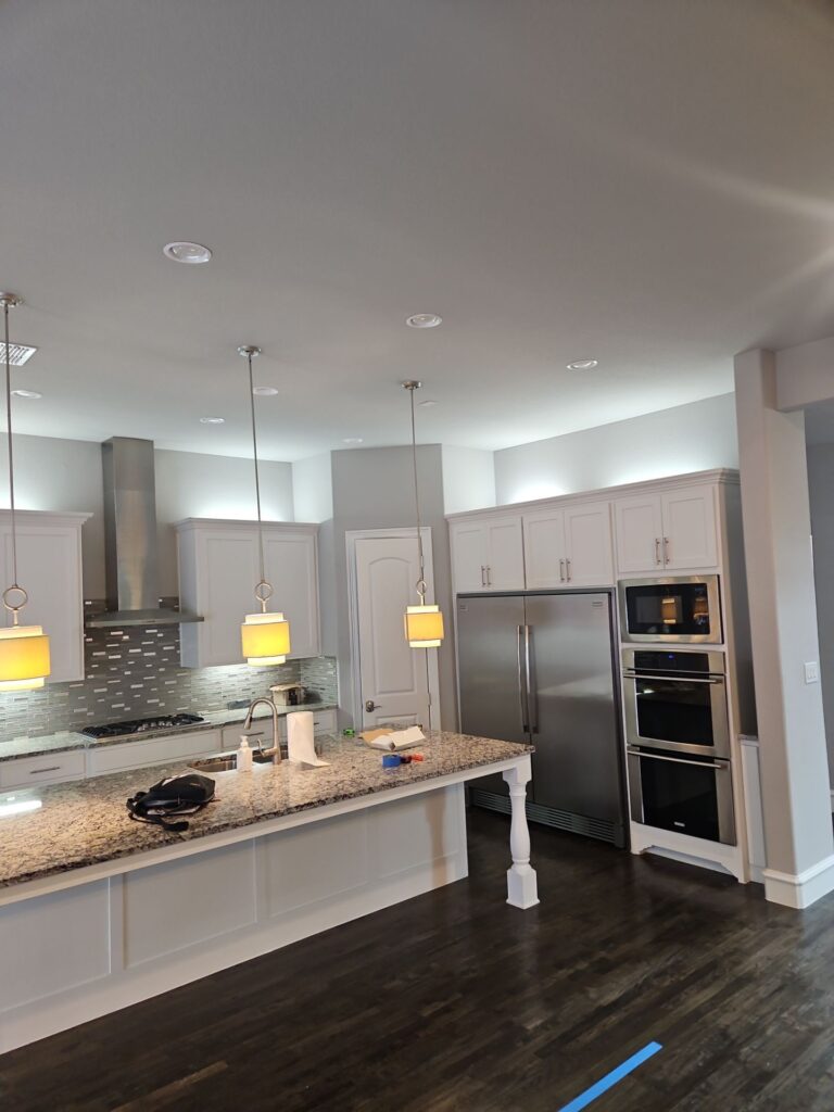 Modern kitchen featuring granite countertops, stainless steel appliances, and pendant lighting, showcasing an open concept design ideal for remodeling in Collin County and DFW.