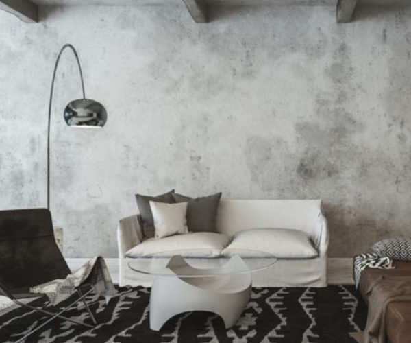 Modern living room with minimalist white sofa, decorative pillows, glass coffee table, and stylish floor lamp, showcasing contemporary interior design.