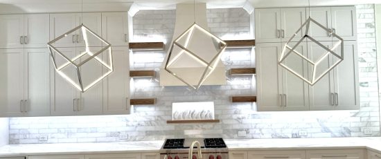 Modern kitchen design featuring custom cabinetry, geometric pendant lights, and marble backsplash, showcasing a stylish and functional remodel for The Perfect Cabinet Company.