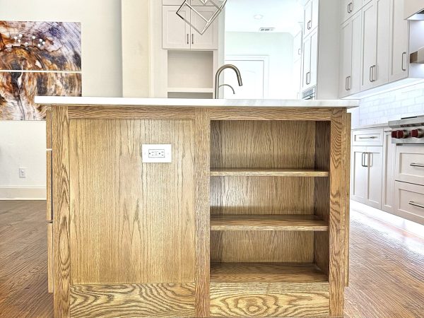 Custom oak bathroom cabinet with open shelving and integrated electrical outlet, showcasing modern design and functionality, enhancing storage and organization in stylish bathroom remodel.
