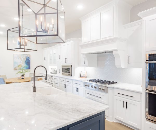 Modern kitchen featuring white cabinetry, marble countertop, stainless steel appliances, and a stylish pendant light, showcasing custom remodeling by The Perfect Cabinet Company in Garland, TX.