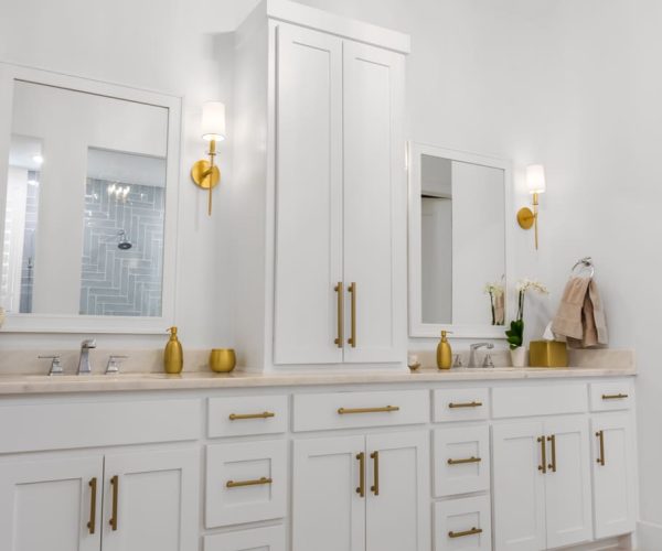 Modern bathroom featuring sleek white cabinetry, gold hardware, and stylish mirrors, showcasing high-quality craftsmanship and design solutions from The Perfect Cabinet Company.