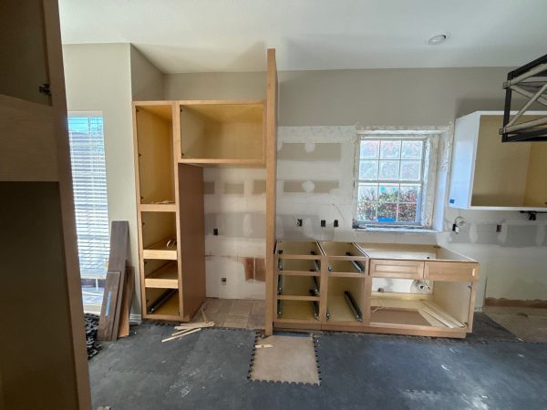 Kitchen remodeling in progress with custom cabinetry installation, featuring open shelving and drawer units, showcasing The Perfect Cabinet's craftsmanship.