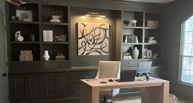 Modern home office featuring custom cabinetry, a sleek desk, and decorative shelving, showcasing a blend of functionality and aesthetic appeal.