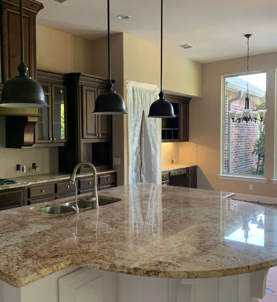 Modern kitchen with dark cabinetry, granite countertops, and pendant lighting, showcasing a spacious layout ideal for remodeling and design considerations.
