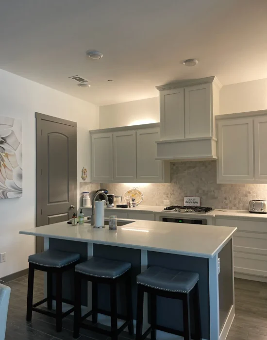 Modern kitchen interior featuring gray cabinets, a white countertop, and stainless steel appliances, illustrating a well-designed space for a kitchen remodel.